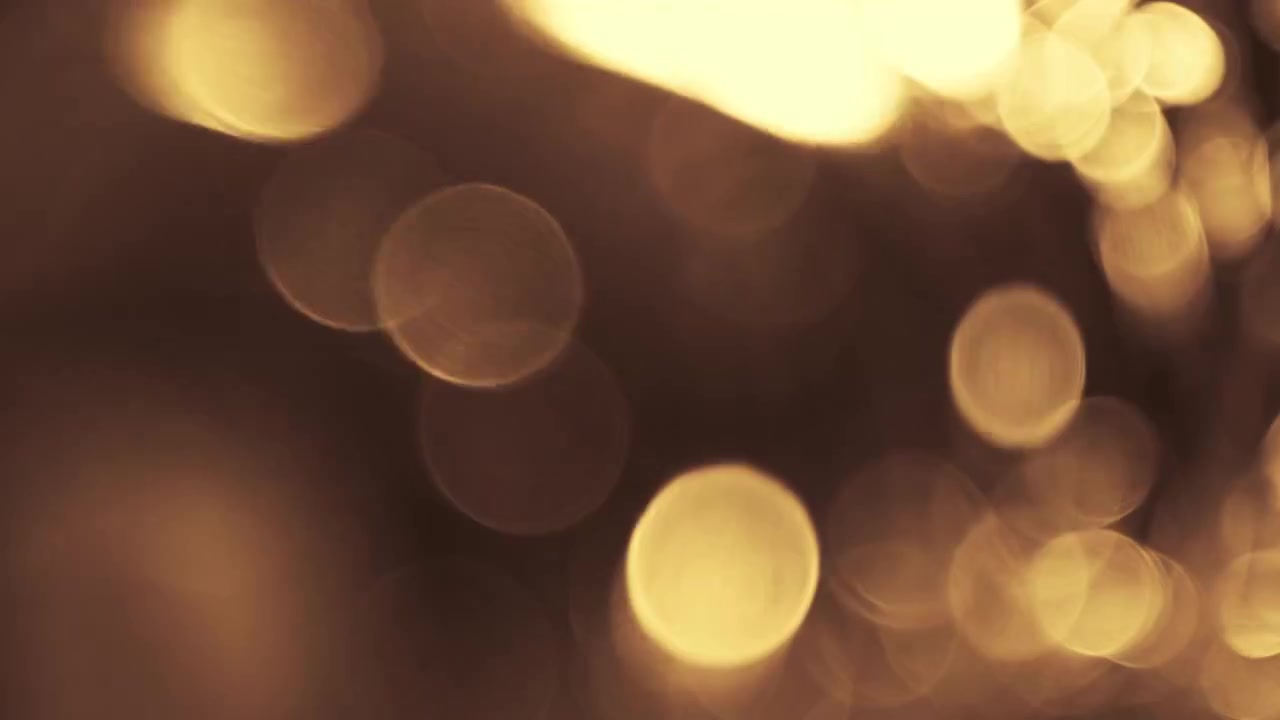 Particelle Bokeh Astratte di Luce Dorata Fluttuanti su Sfondo Nero