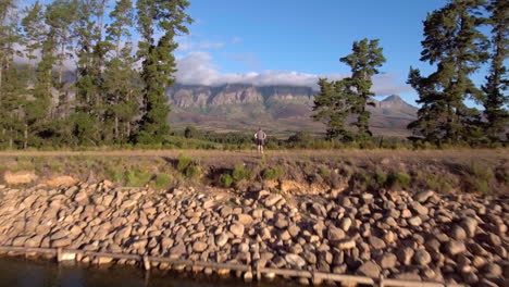 Fly-through-shot-of-man-standing-in-rural-landscape