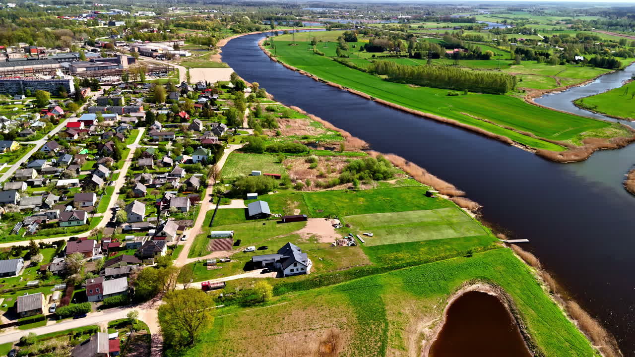 Scenic Aerial View of Joniškis With Riverfront Homes and Verdant Countryside