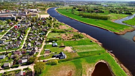 Scenic Aerial View of Joniškis With Riverfront Homes and Verdant Countryside