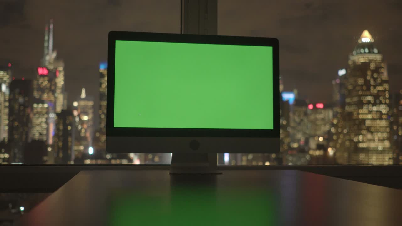 computadora con pantalla verde en un edificio de oficinas moderno con fondo de paisaje urbano.