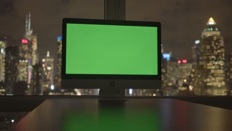 computadora con pantalla verde en un edificio de oficinas moderno con fondo de paisaje urbano.