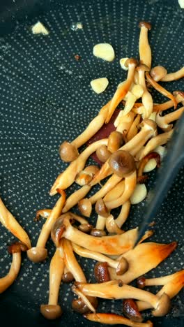 frying mushrooms with garlic in a pan