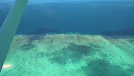 Gran-Barrera-De-Coral-Vuelo-Panorámico-Disparo-Aéreo-Desde-La-Ventana-Del-Avión