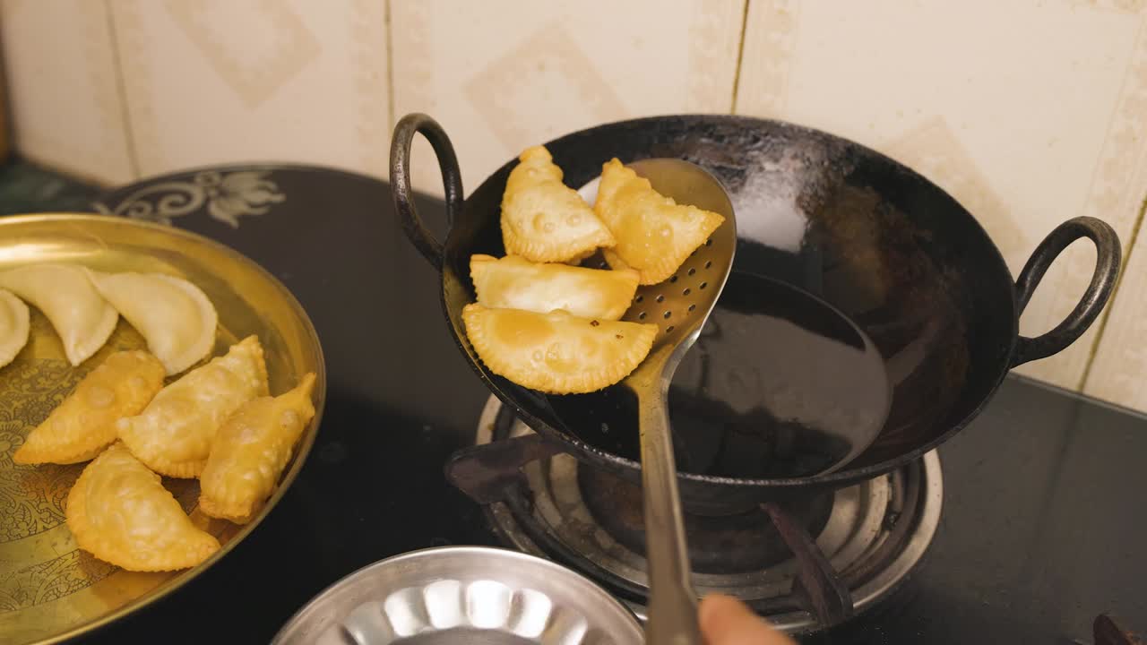 An Indian woman deep frying  gujia, an Indian popular snack especially made in Holi festival of colors