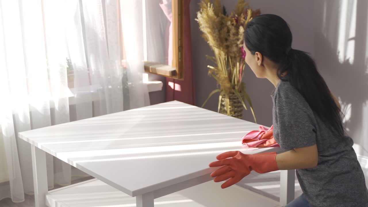 Intensive house cleaning. Wiping the table with a cloth, wiping the dust.