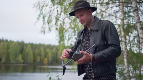 hombre caucásico desplegando las hélices de un dron dji en la naturaleza