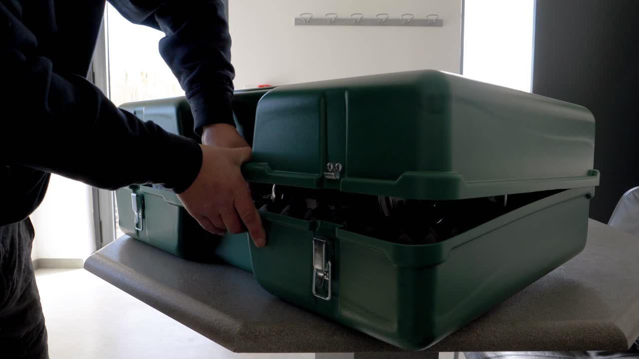 toma en cámara lenta de un hombre apretando su estuche con objetos de valor de vidrio dentro