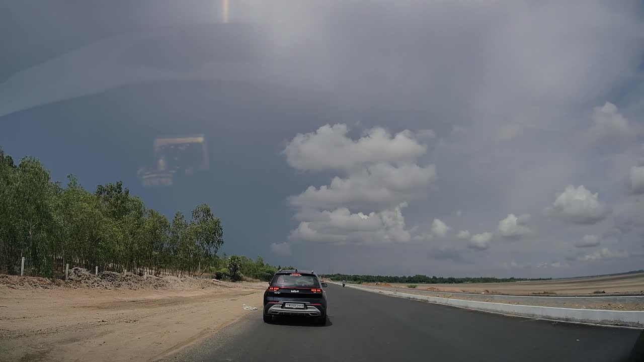 Driving on a rural road with traffic under an overcast sky