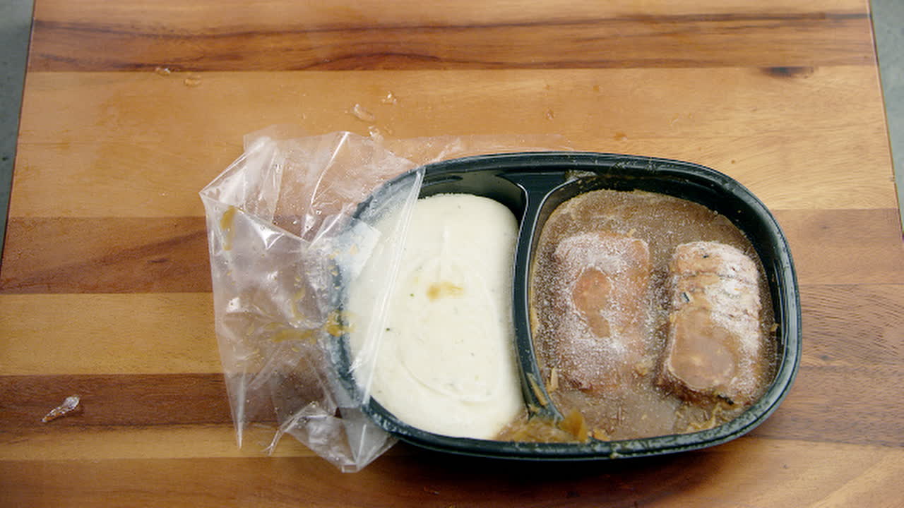 recipiente de comida congelada que se deja caer sobre la mesa del comedor y se recoge