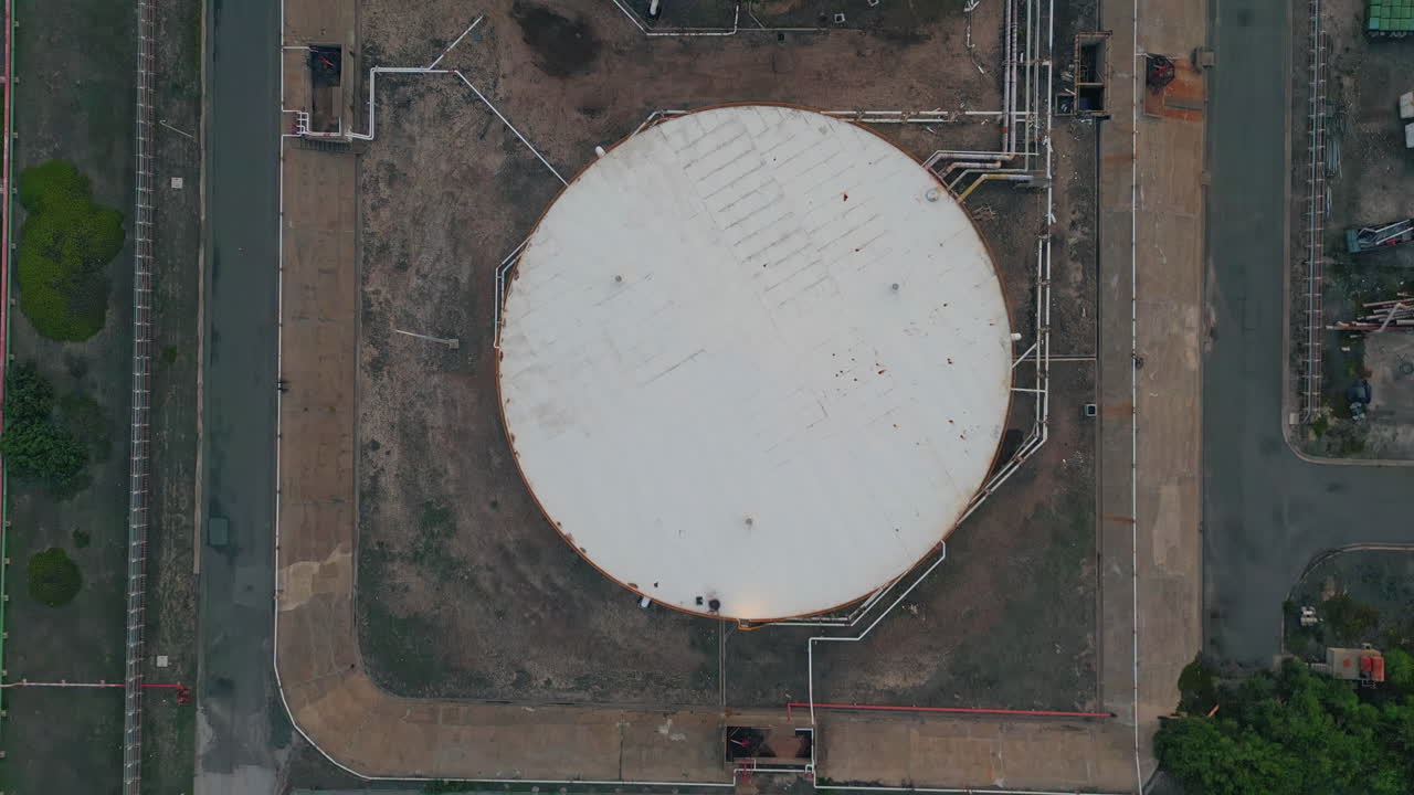 Oil storage tanks top view. Drone flying industrial facility with fossil fuel