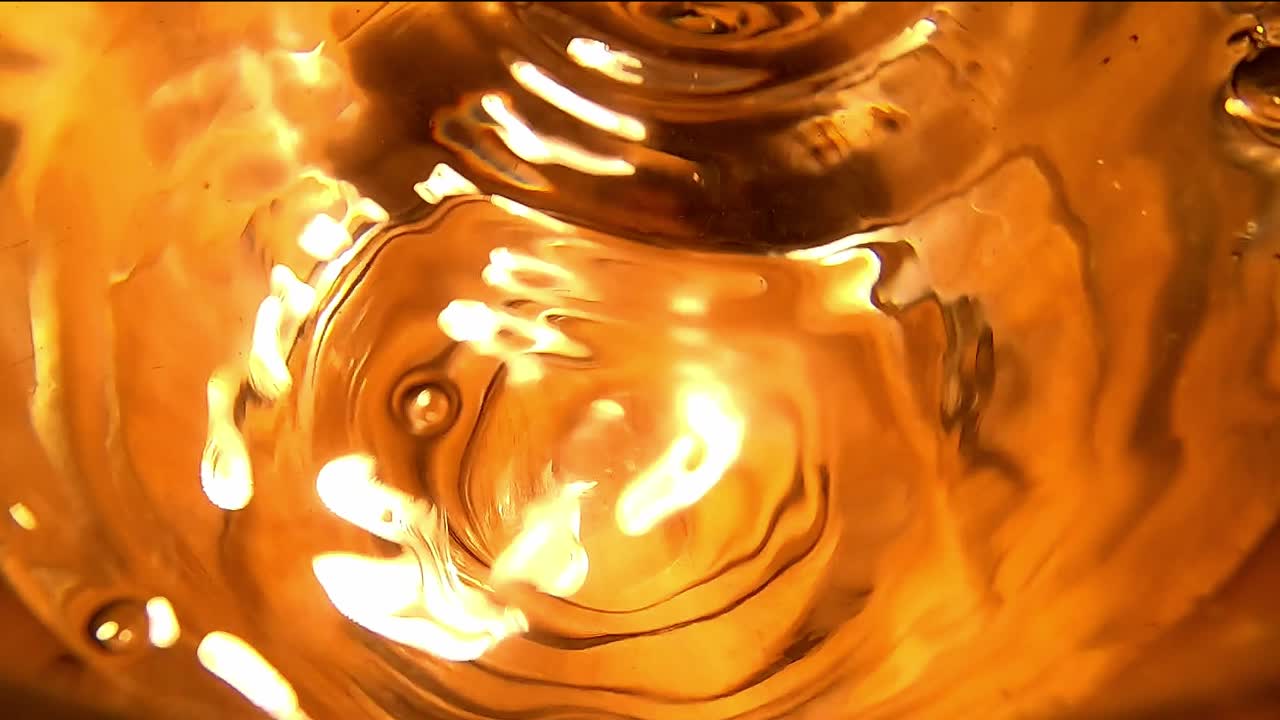 крупный план капель воды, падающих в полный стакан