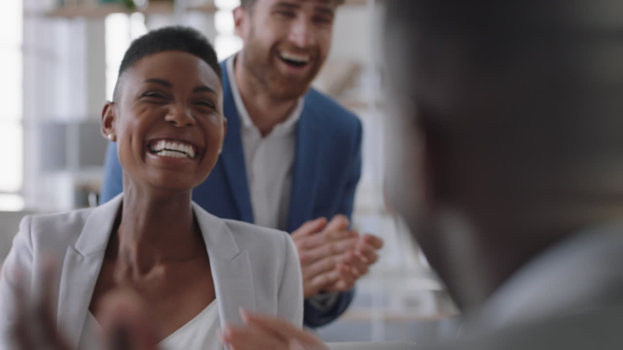 african american business woman celebrating with colleagues high five in office meeting having fun celebration sharing teamwork victory in workplace