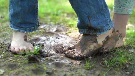 children's bare feet playing with mud on a sunny day