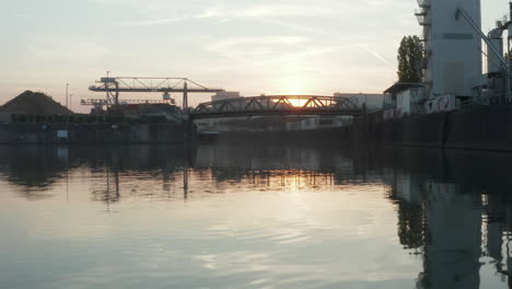 Hafendockbereich-Bei-Sonnenaufgang-Mit-LKW,-Der-Eine-Brücke-Passiert,-Niedriger-Dolly-Nach-Vorne