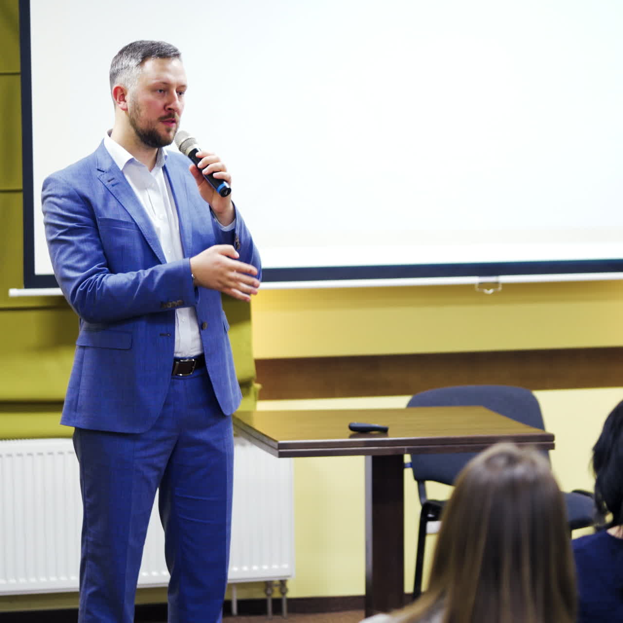 Speaker on the podium. People at the conference hall.