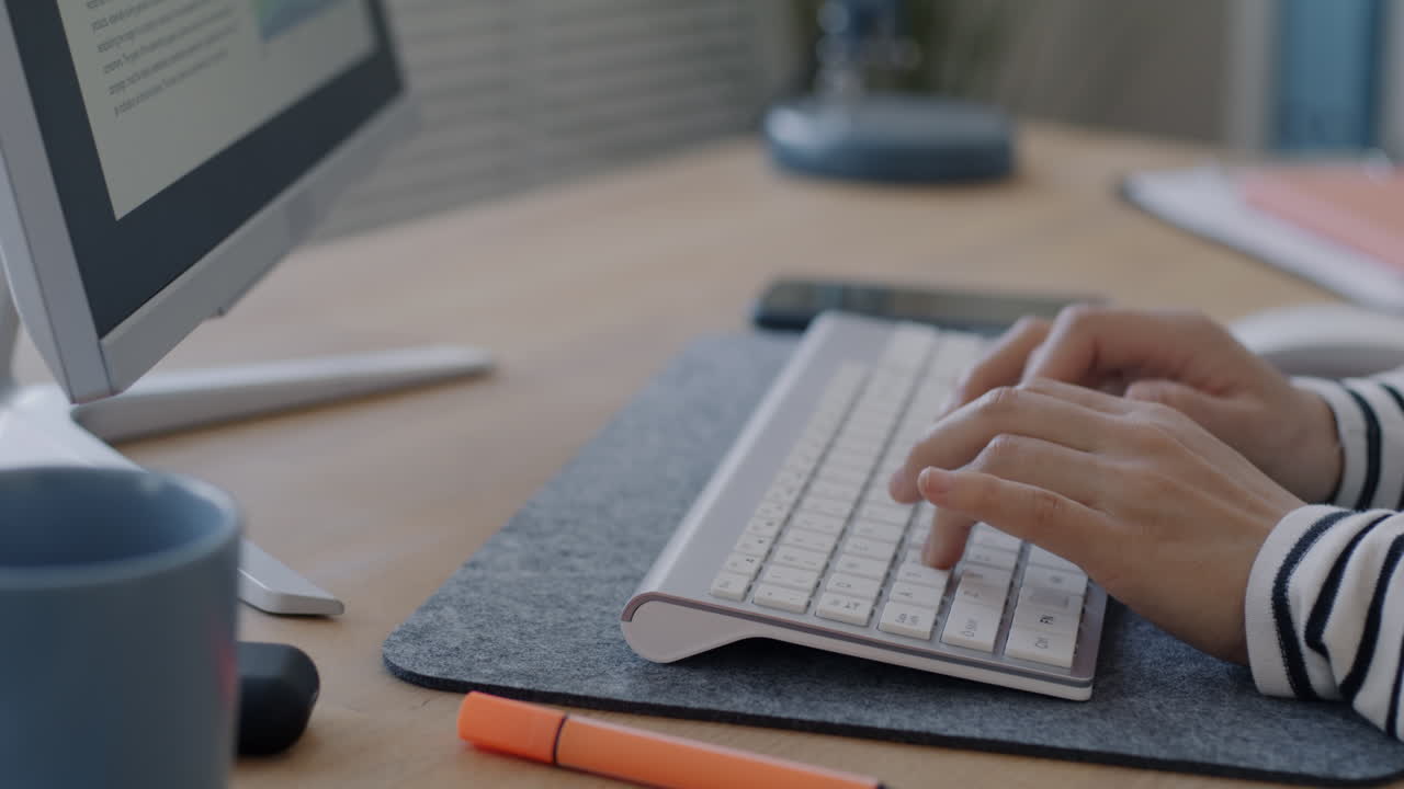 Person typing on a keyboard at a desk