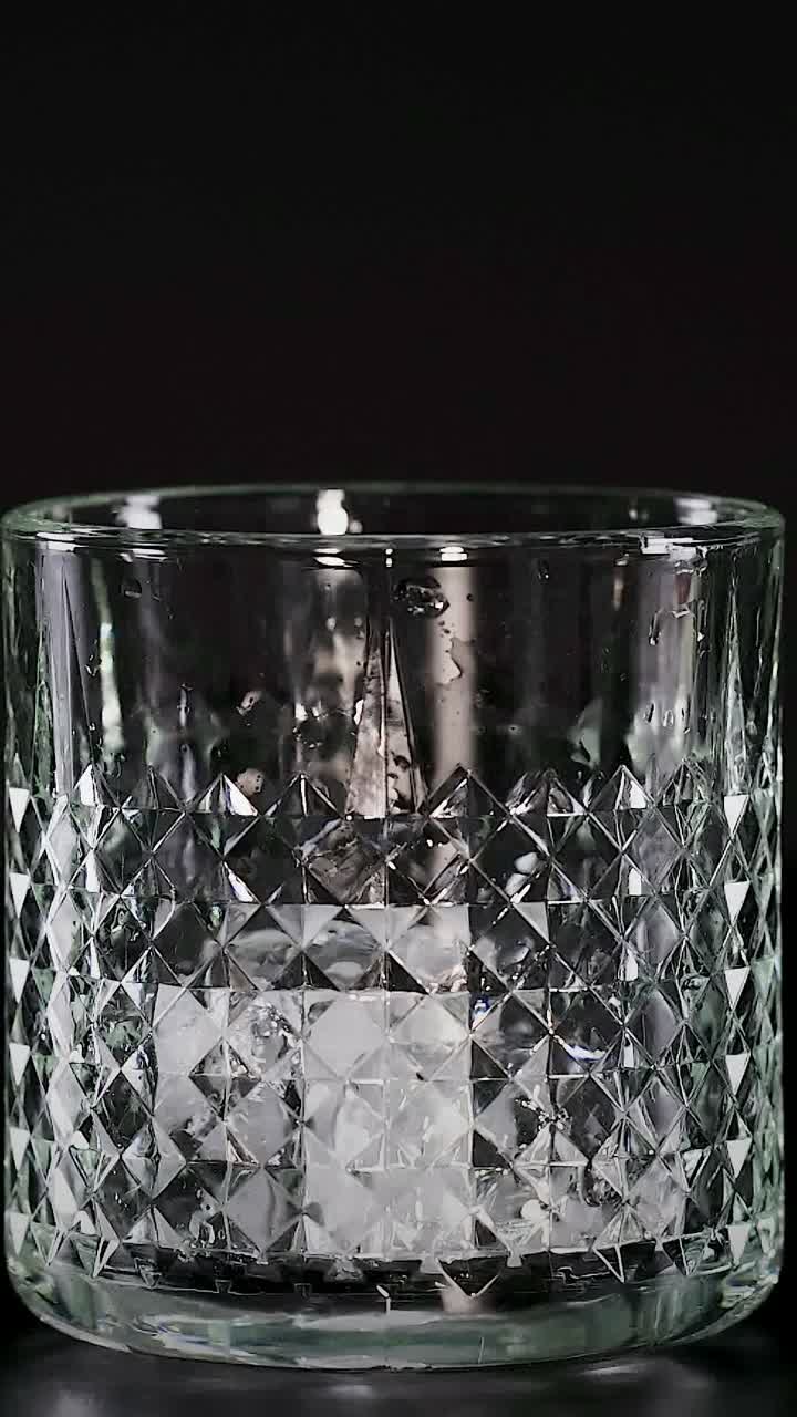 una rebanada de cal cae en un vaso con hielo