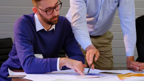 executives discussing over blueprint in conference room at office 4k