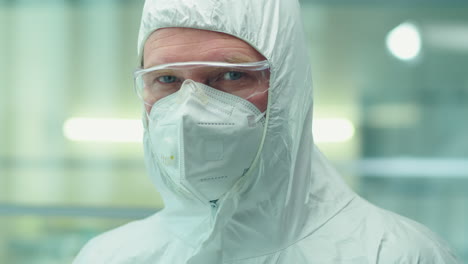 portrait of senior scientist in protective coverall suit and mask