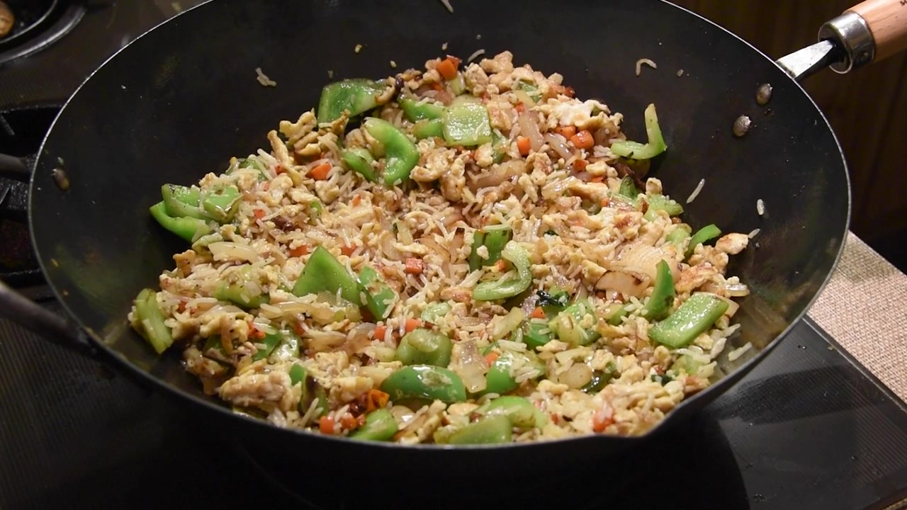 Nasi goreng gyoza Jepang buatan rumah yang lezat dengan telur dan sayuran yang dimasak dalam wajan tradisional. Hidangan makan malam masakan Asia klasik.