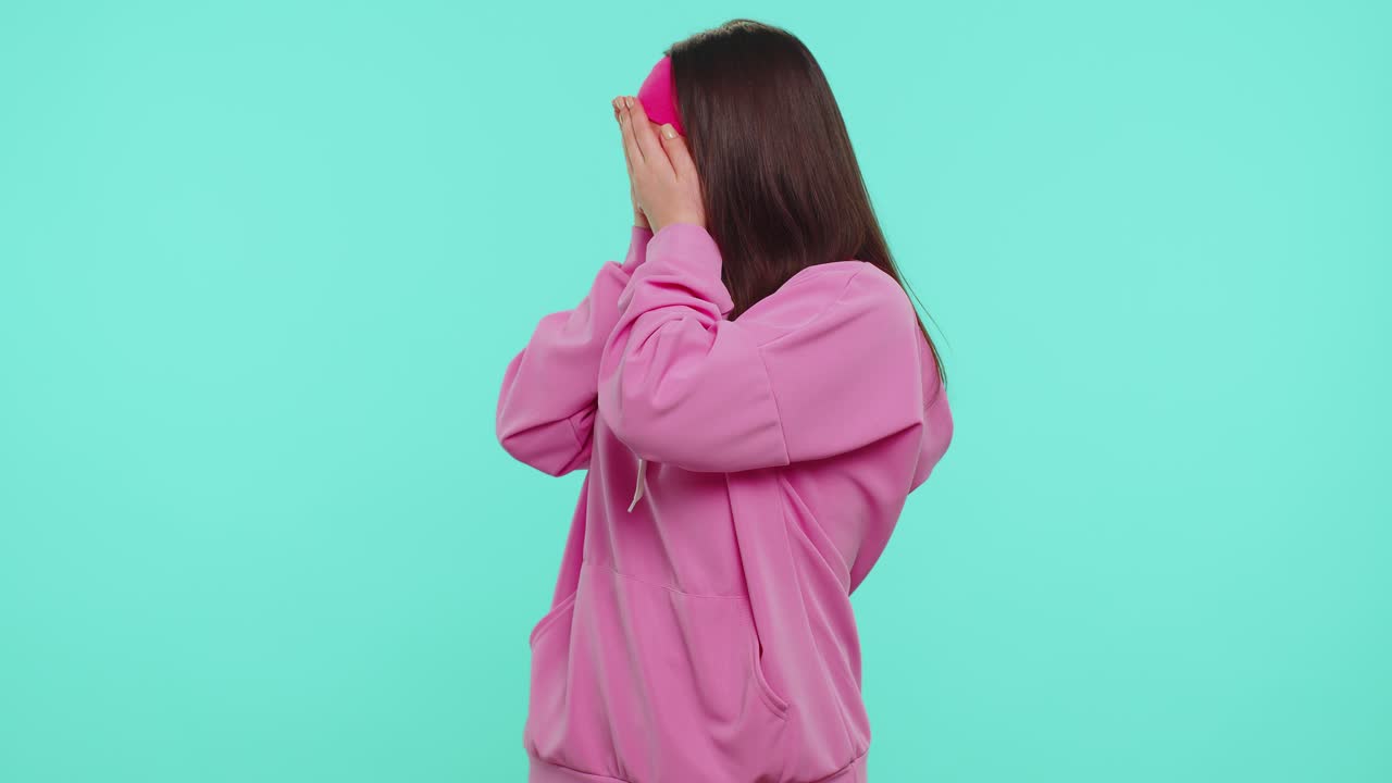 Student girl in pink hoodie closing eyes showing stop gesture confused shy scared to watch