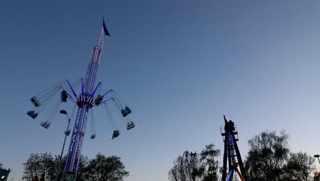 Buntes-Karussell-In-Bewegung-Mit-Sonnenuntergang-Im-Hintergrund