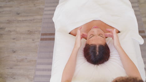 above beautiful woman lying on a massage bed