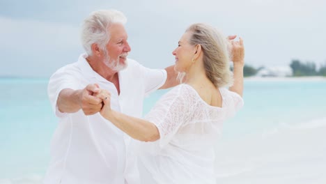 una pareja caucásica senior compartiendo un beso en una playa tropical.