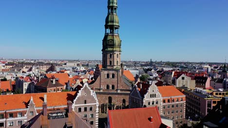 st peters church rises among rooftops, drone smoothly flies closer, riga latvia