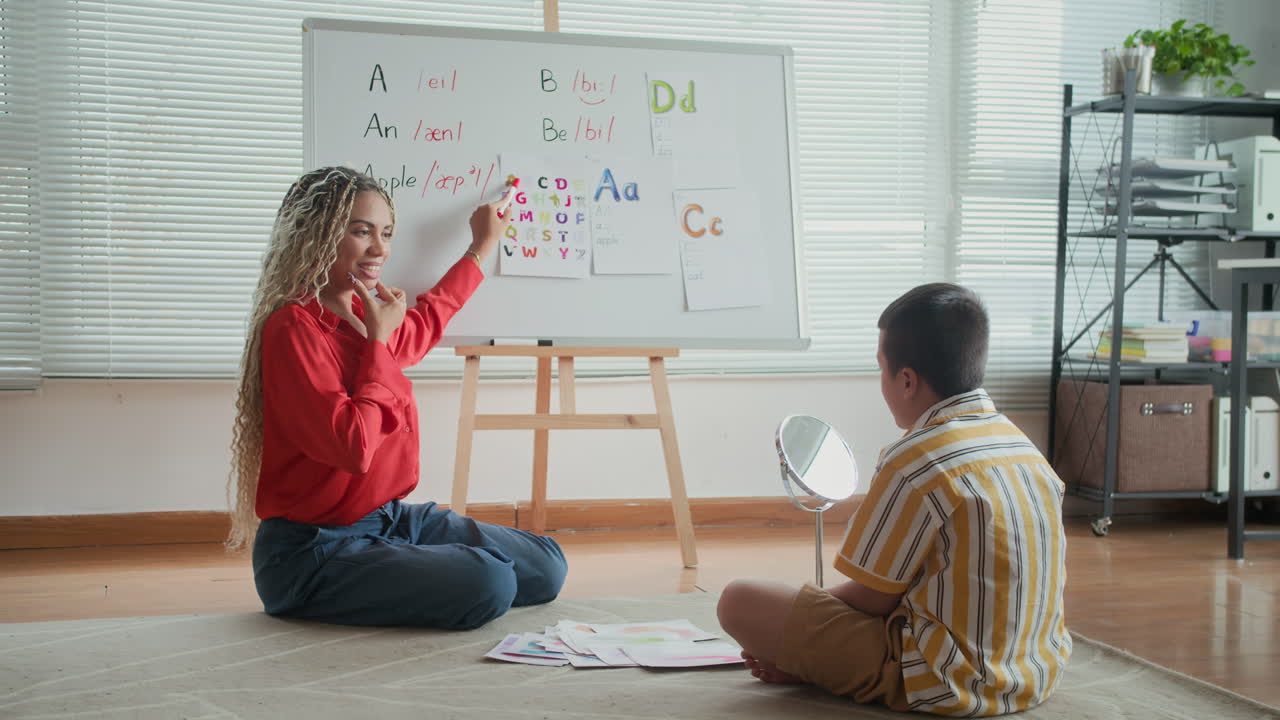 Schoolboy Looking at Speech Therapist Teaching to Pronounce Letters Correctly