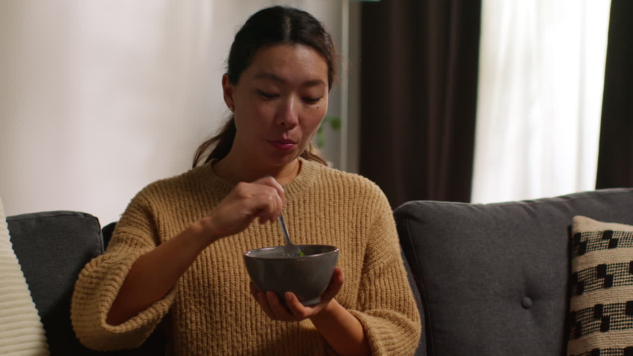 집에서 소파에 앉아 건강한 채식주의자 또는 채식주의자를 먹고 와인 한 잔과 함께 tabbouleh 러드를 먹고 노트북 1에서 쇼를보고 있습니다.