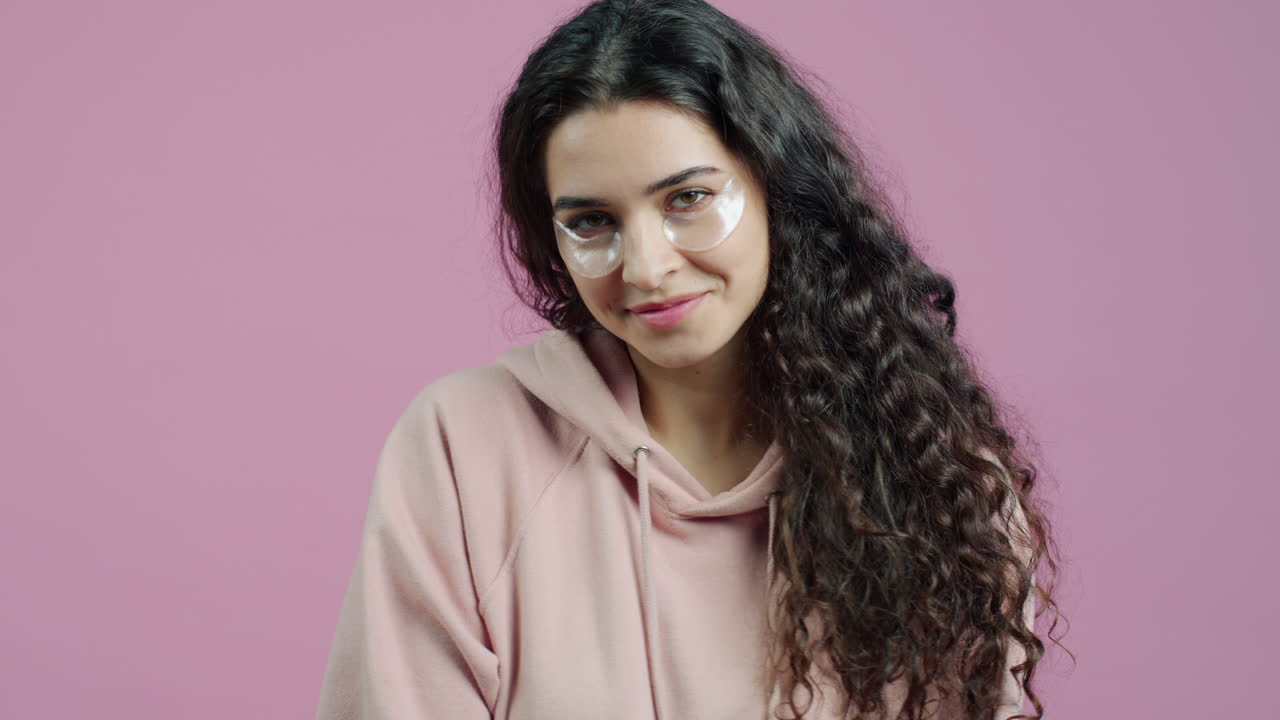 mujer aplicando parches en los ojos