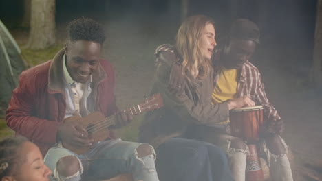 friends enjoying music at night campfire