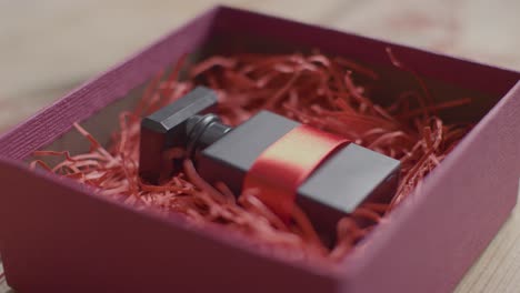 close up shot of romantic valentines present of perfume gift wrapped in box on table