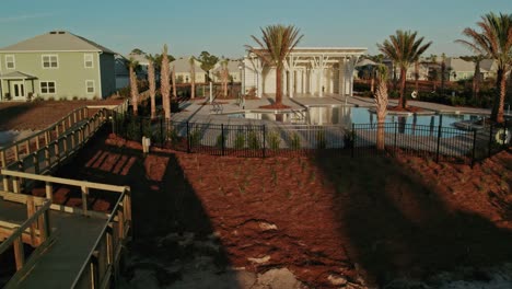 aerial along a beach boardwalk towards a tropical florida swimming pool