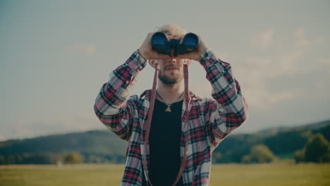 joven turista masculino mirando a través de un binocular