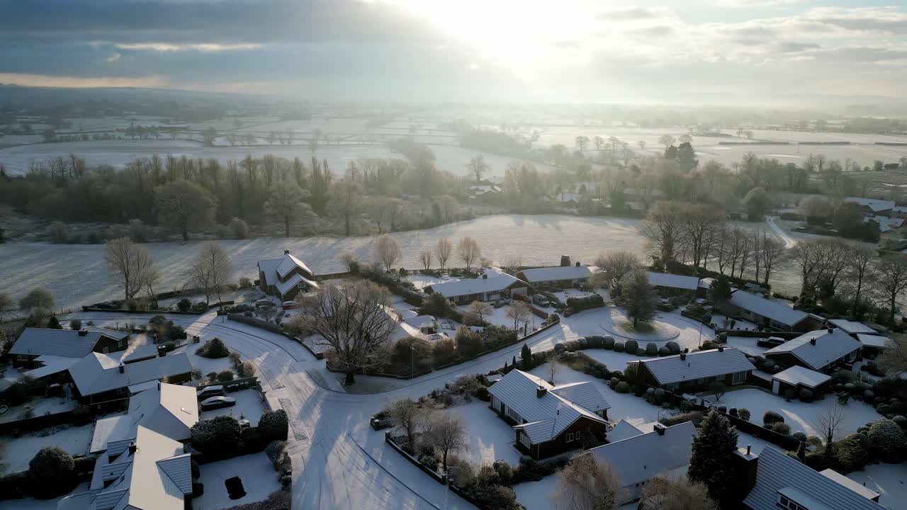 A picture-perfect English village seen from above, its snowy landscape sparkling in the morning sunlight.