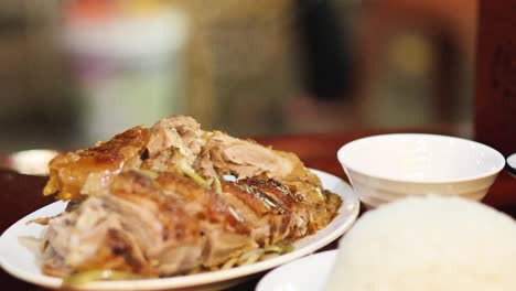 palillos que levantan el pato asado sobre el arroz en una comida