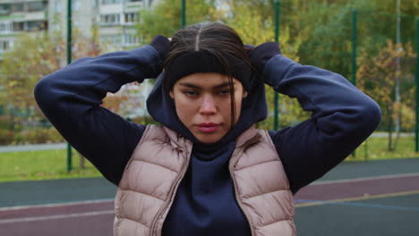 woman putting hoodie on