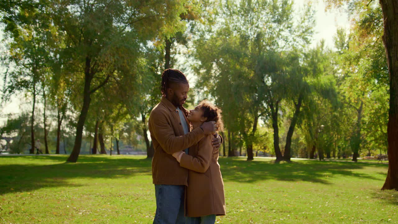 un padre sonriente abrazando a su hija tocando suavemente a su hijo. amor incondicional del padre.