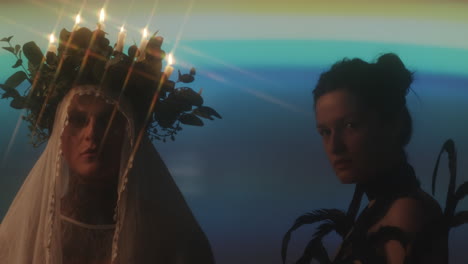 man with candle wreath and woman in feather outfit