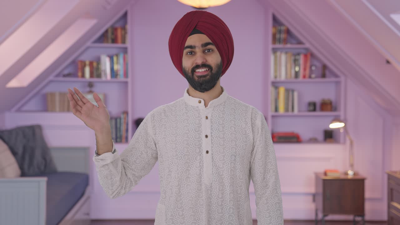 Uomo indiano Sikh felice che saluta