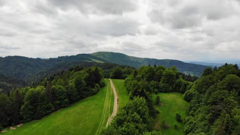 dirt road on ridge of beskid sadecki mountains, poland, aerial view