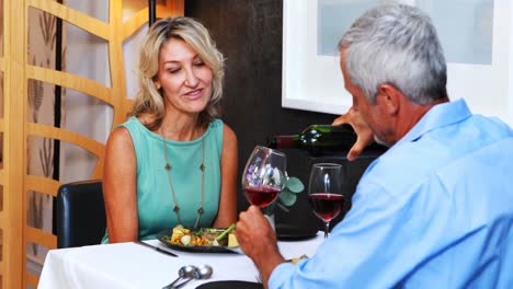 Mature-couple-interacting-with-each-other-in-restaurant