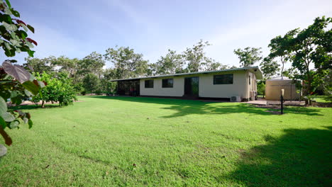 Gran-Propiedad-Rural,-Pequeña-Casa-Rectangular-Con-Un-Gran-Patio-Trasero-En-Un-Día-Soleado,-La-Plataforma-Rodante-Revela-El-Follaje-Pasado