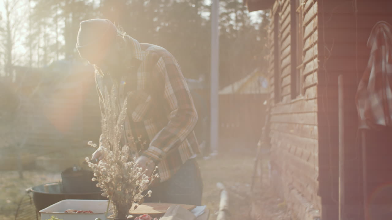 바 ⁇ 에서 바비큐를 조리하는 동안 고기와 함께 개를 먹이는 사람