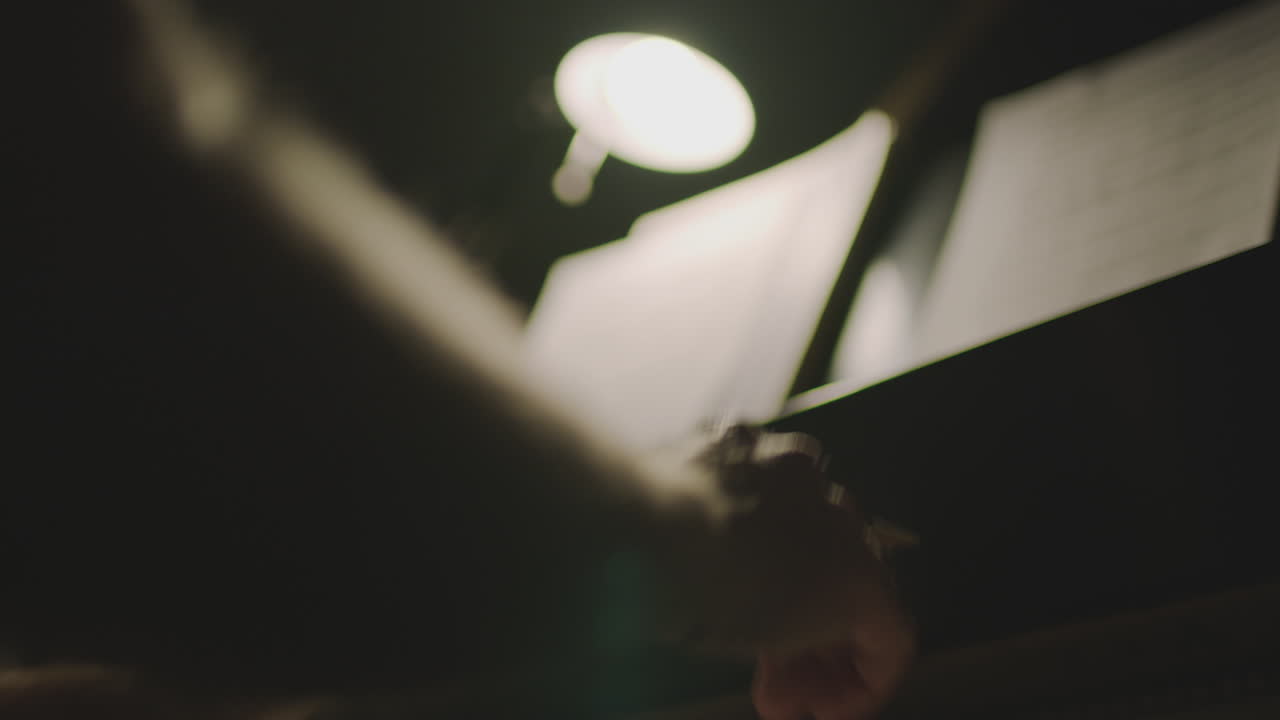 A person is playing a piano in the dark