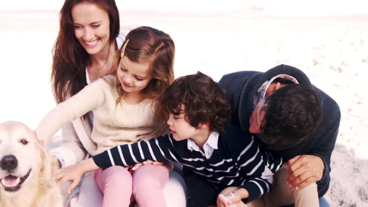 귀여운 가족이 개를  ⁇ 안고 있습니다.