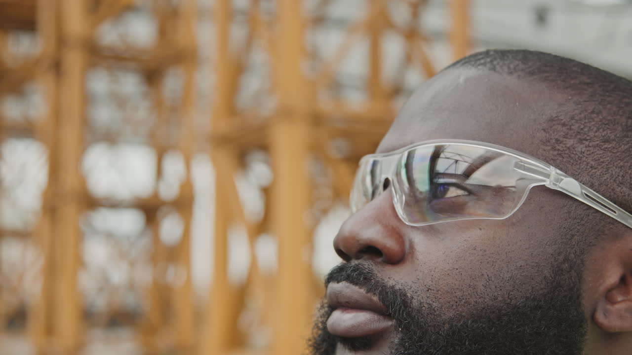 Black Male Worker Putting On Noise-Canceling Earmuffs